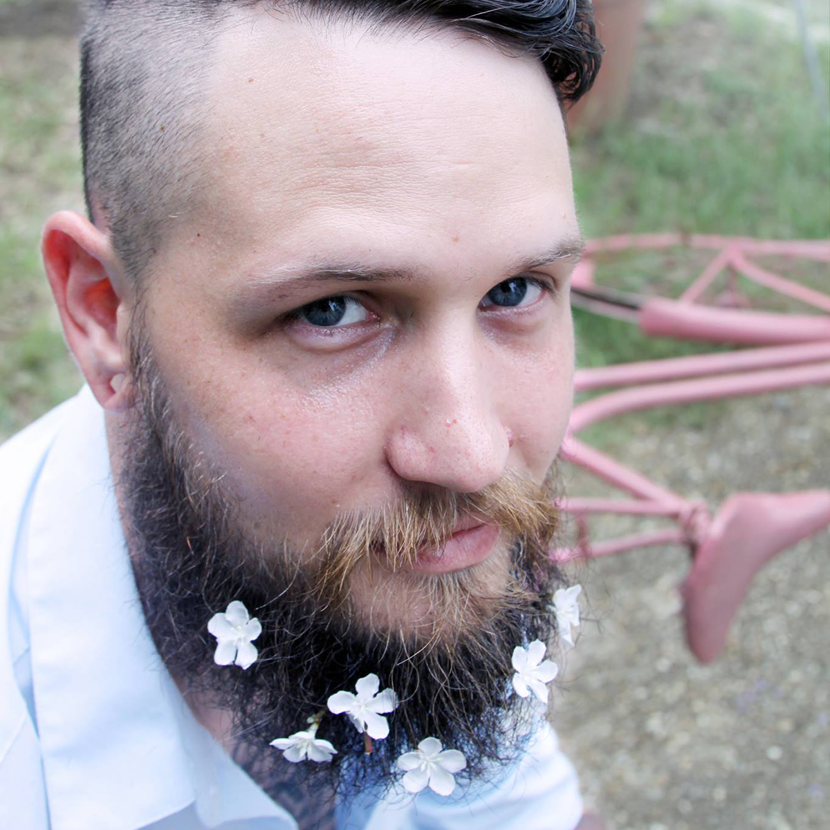 Un homme avec des fleurs dans sa barbe